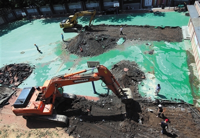 6月17日，施工人员正在对北京实验二小白云路分校操场的塑胶跑道进行拆除。新京报记者王贵彬摄