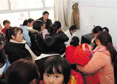 2月22日，在河南省商丘市柘城县人民医院，退休后被返聘的儿科医生张玉芝在坐诊，屋子里面挤满了等待就诊的儿童和家长。新华社记者冯大鹏摄